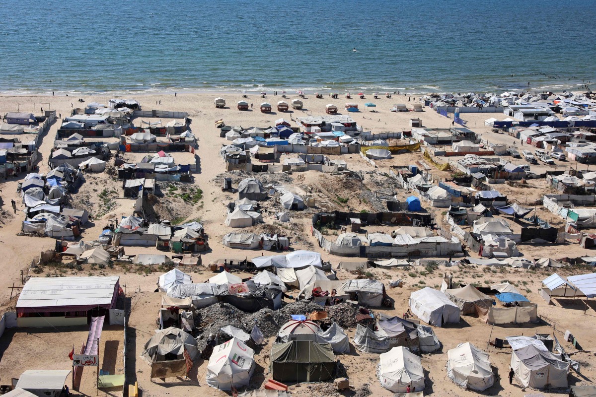 Tents and shelters for Palestinians displaced by conflict are pictured erected at a make-shift camp along the beach near the seaport in the west of Gaza City on July 19, 2025. (Photo by Omar AL-QATTAA / AFP)
