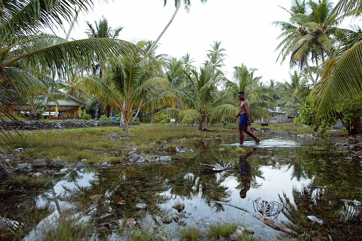 Water welling from the rocky ground forms a new lake in the centre of Amatuku Islet as king tides hit Funafuti Atoll on February 20, 2004. Photo by Torsten BLACKWOOD / AFP