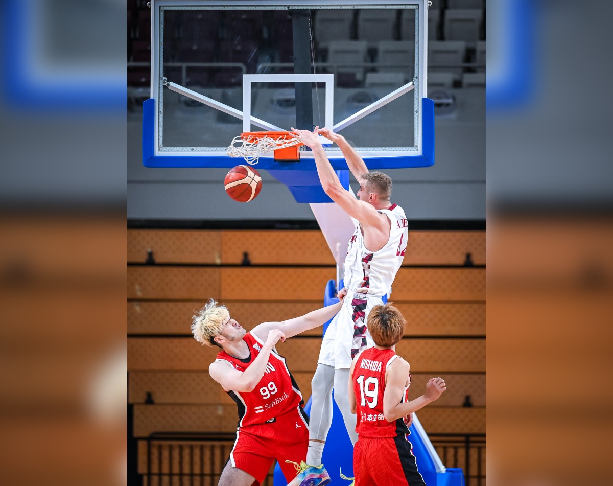 Qatar's Alen Hadzibegovic scores with a dunk against Japan.