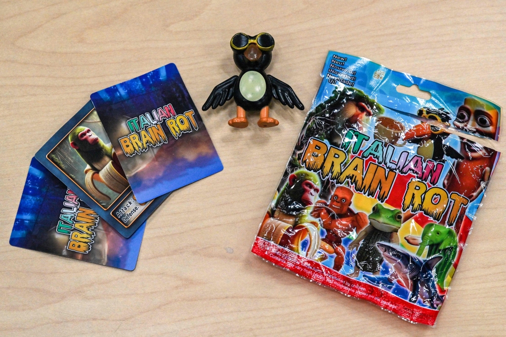 This photo illustration taken on August 7, 2025 shows a small bag of novelty merchandise for the online phenomenon called Italian Brainrot, containing collectable cards and a small figure of Frulli Frulla (C), purchased from a shop in Tokyo. (Photo by AFP) 