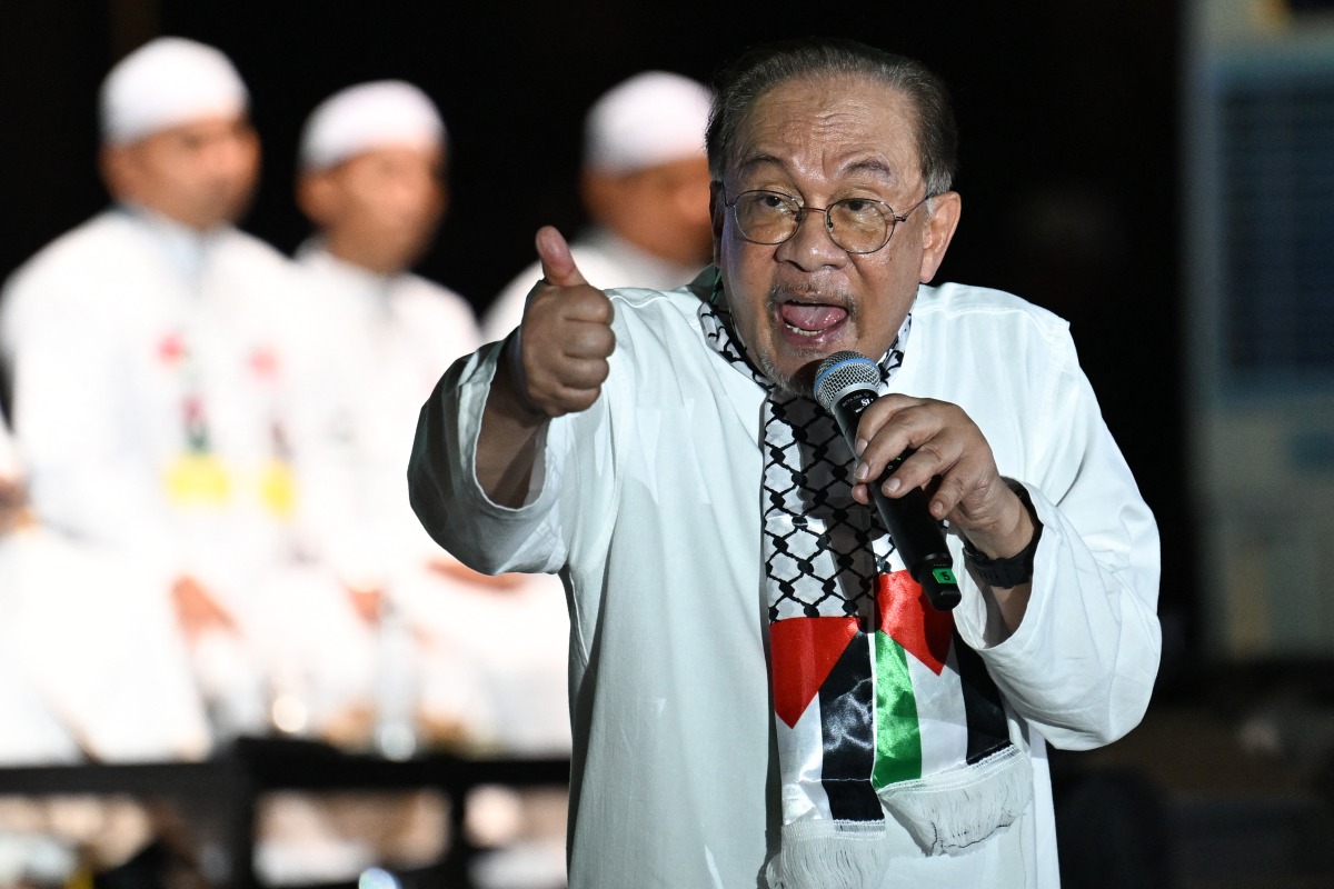 Malaysia's Prime Minister Anwar Ibrahim speaks during a rally and flags off Gaza aid mission in Kuala Lumpur on August 24, 2025. (Photo by Mohd RASFAN / AFP)
