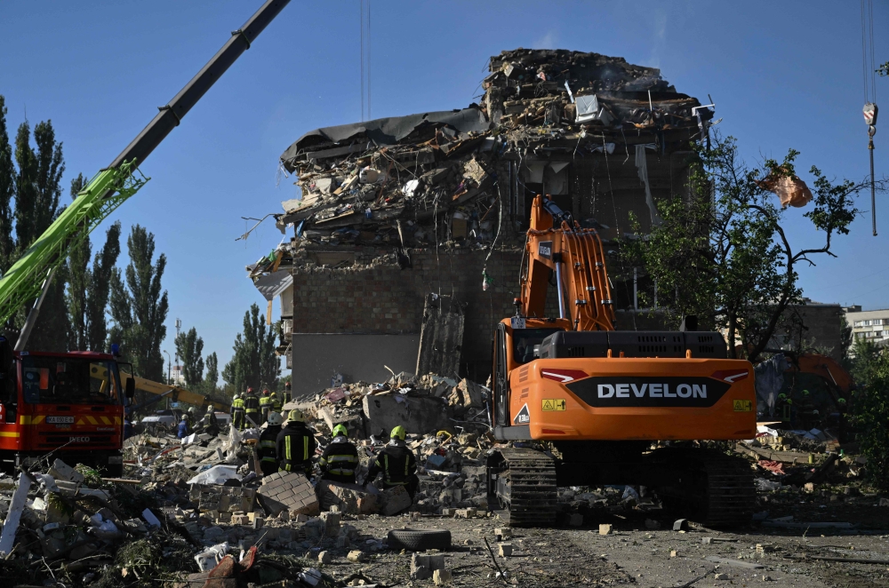 Ukrainian rescuers conduct a search and rescue operation in and around a residential building heavily damaged during a large-scale Russian attack on Kyiv on August 28, 2025. (Photo by Genya Savilov / AFP)