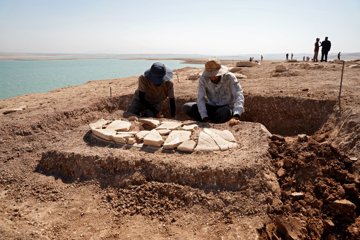 Members of the Dohuk Antiquities Department work on a grave unearthed on the banks of Mosul Dam on an archaeological site in the Khanke sub-district of Dohuk Governorate on August 30, 2025. Photo by Ismael ADNAN / AFP.
