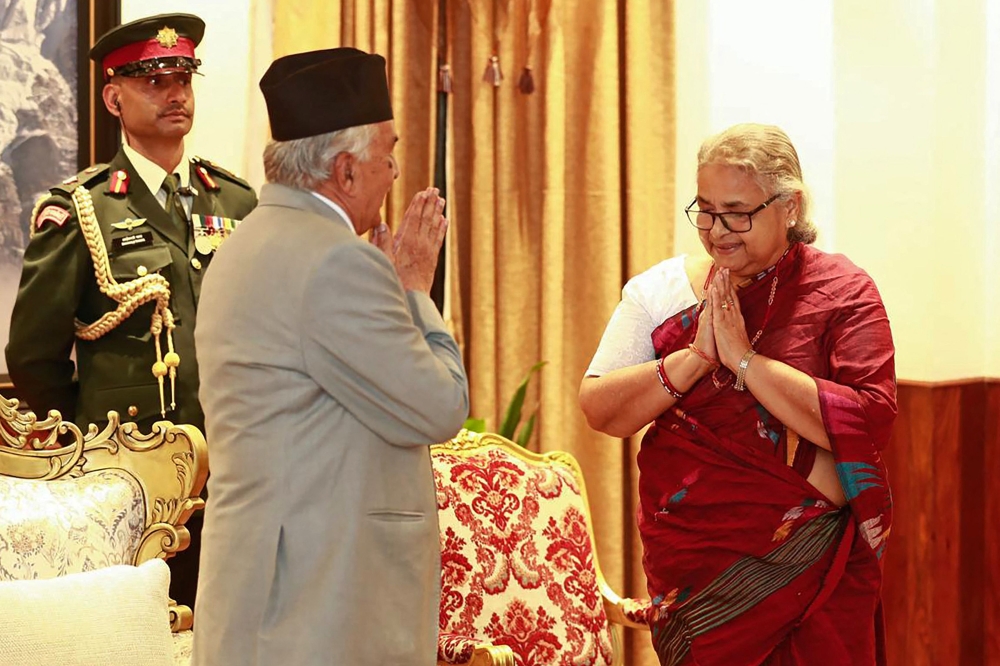 Nepal's President Ram Chandra Paudel gestures after administering the oath to the country's newly appointed Prime Minister Sushila Karki during her swearing-in-ceremony at the President House in Kathmandu on September 12, 2025. (Photo by Sujan Gurung / AFP)
 