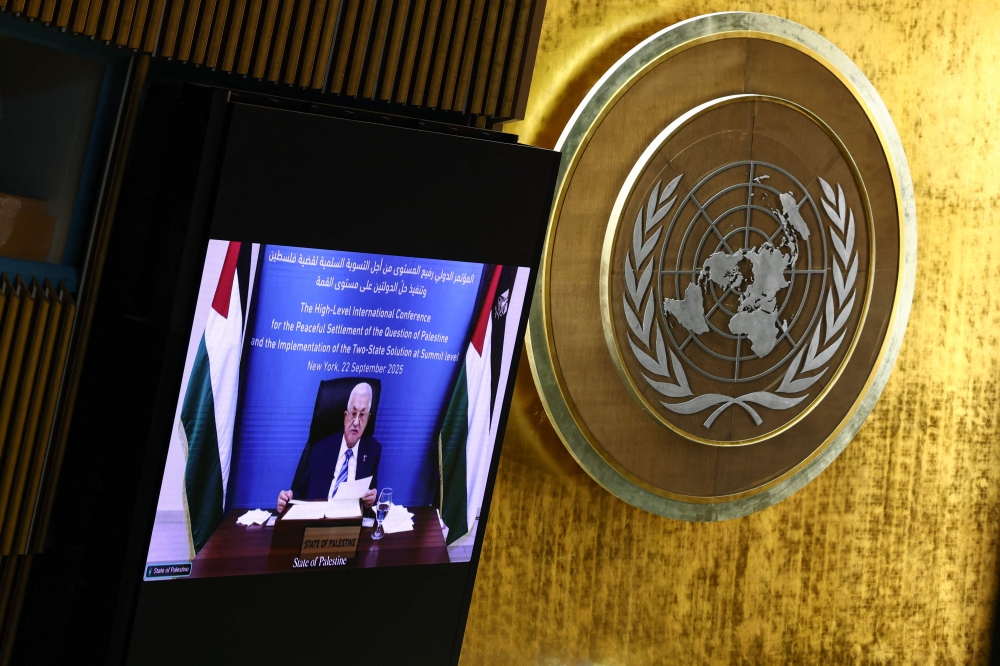 Palestinian Authority President Mahmud Abbas is displayed on a screen as he speaks remotely during a United Nations Summit on Palestinians at UN headquarters during the United Nations General Assembly (UNGA) in New York on September 22, 2025. (Photo by Angela Weiss / AFP)
