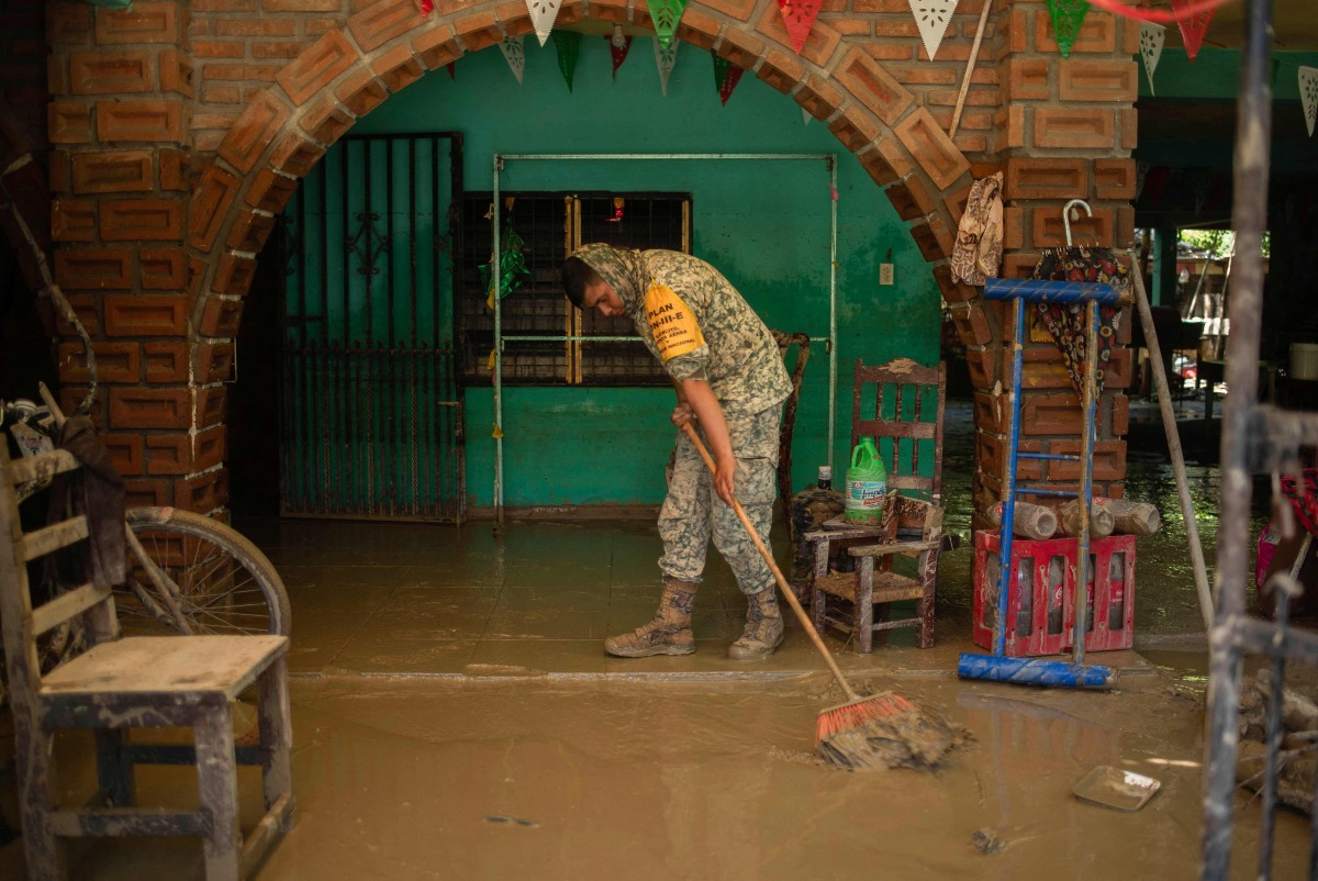 A Mexican Army soldier works to remove the mud from a flooded house due to the heavy rains in the municipality of Alamo, Veracruz, Mexico, on October 12, 2025. Photo by Hector Quintanar / AFP