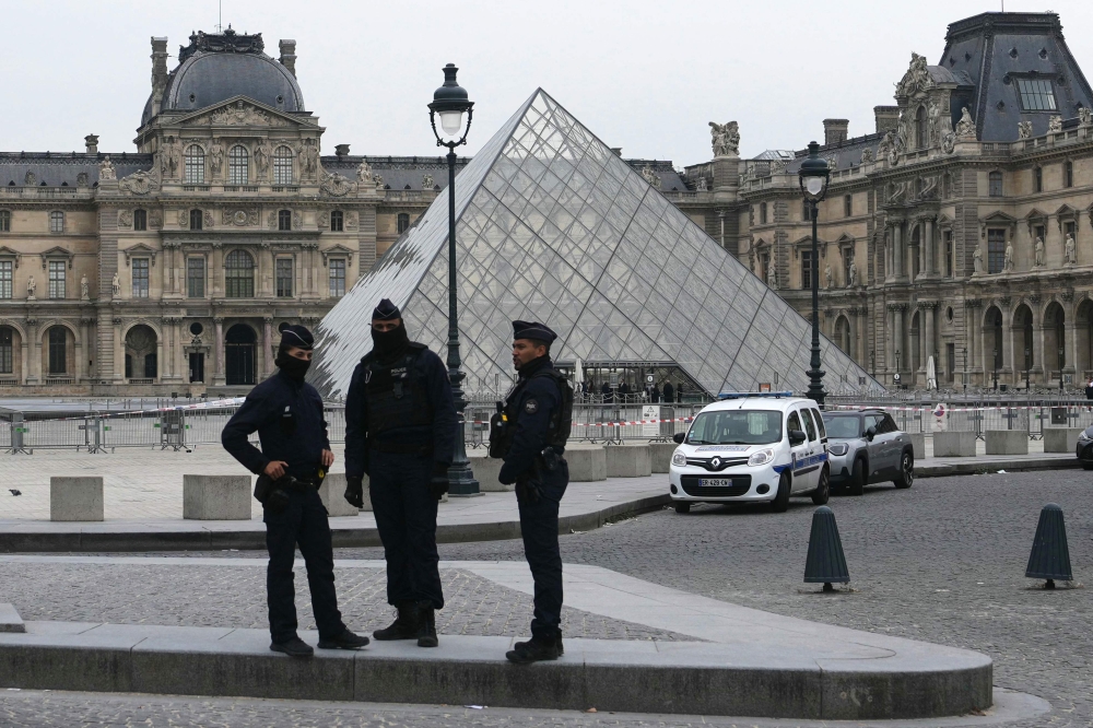French police officers stand in front of the Louvre Museum after robbery, in Paris on October 19, 2025. (Photo by Dimitar Dilkoff / AFP) 
