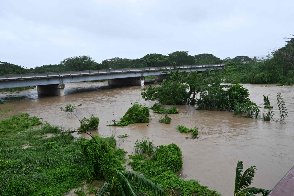 The Rio Cobre comes out of its banks near St. Catherine, Jamaica, on October 28, 2025. (Photo by Ricardo Makyn / AFP)