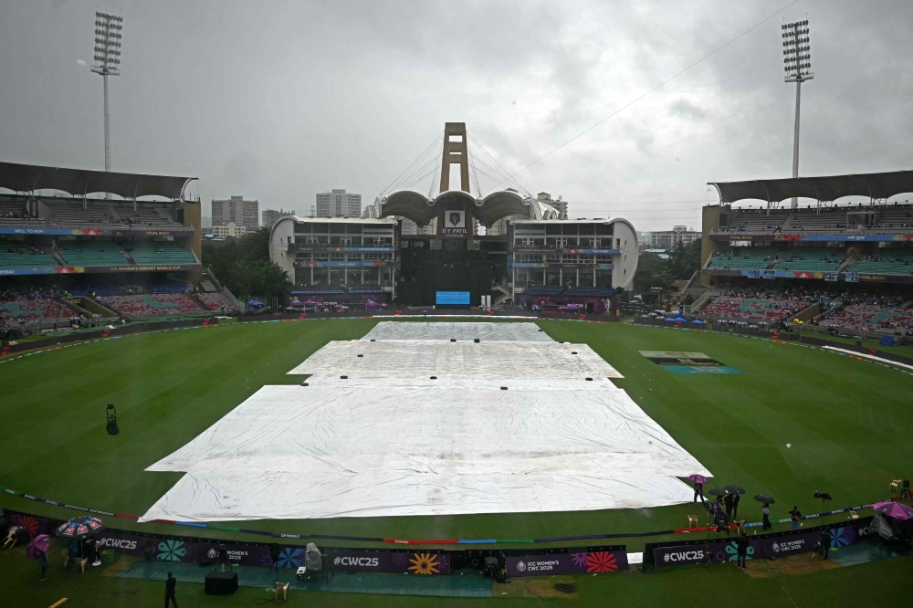 Raincovers are spread over the pitch before the start of the ICC Women's Cricket World Cup 2025 one-day international (ODI) final match in Navi Mumbai on November 2, 2025. (Photo by Punit Paranjpe / AFP) 