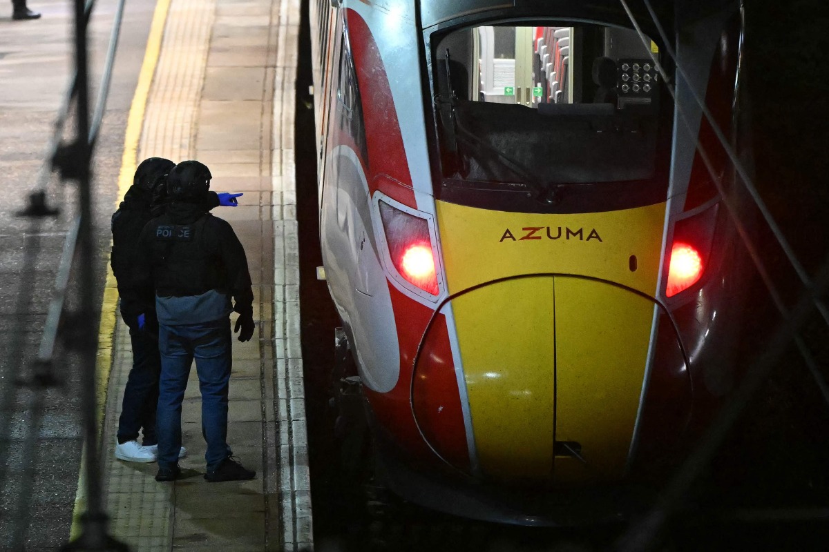 Police officers work on the platform alongside an LNER Azuma train at Huntingdon Station in Huntingdon, eastern England, on November 1, 2025, following a stabbing on a train. Photo by JUSTIN TALLIS / AFP