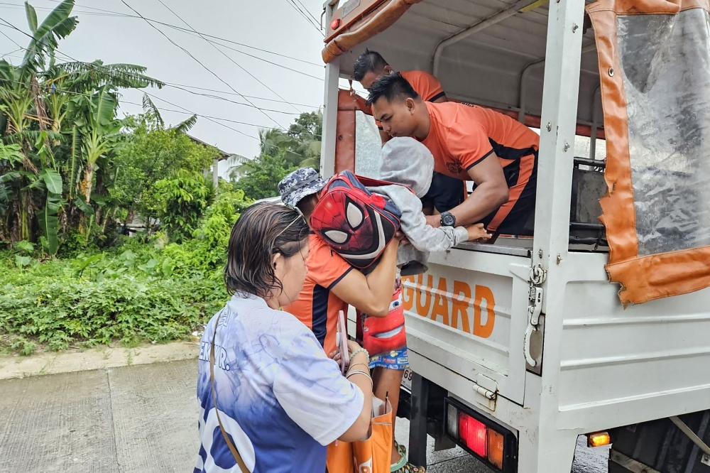 The Philippine Coast Guard personnel assisting in evacuating residents in Guiuan town, ahead of the landfall of Typhoon Kalmaegi. Photo by handout / Philippine Coast Guard station / AFP 