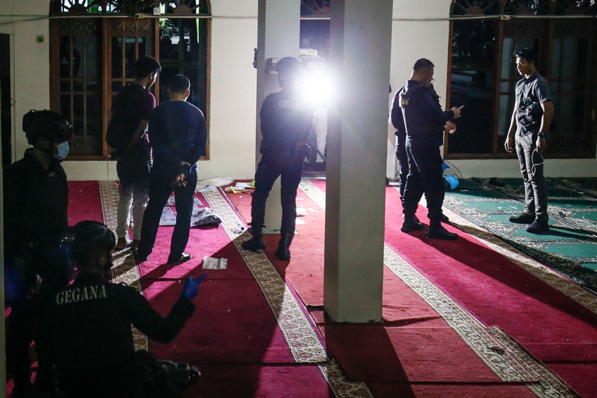 Police officials carry out an on-site investigation following a blast at a mosque inside a school in Jakarta on November 7, 2025. (Photo by CANDRA / AFP)
