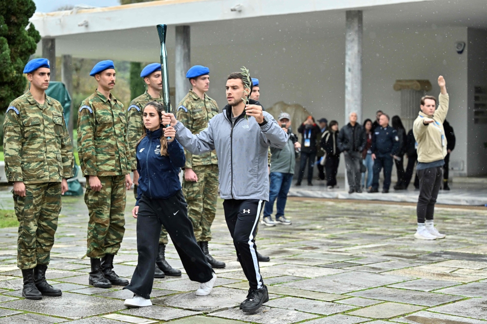 Performers take part in a rehearsal of the lighting of the Olympic flame for the Milano-Cortina 2026 Winter Olympic Games, at the Museum of Ancient Olympia, in Olympia on November 25, 2025. (Photo by Aris MESSINIS / AFP)