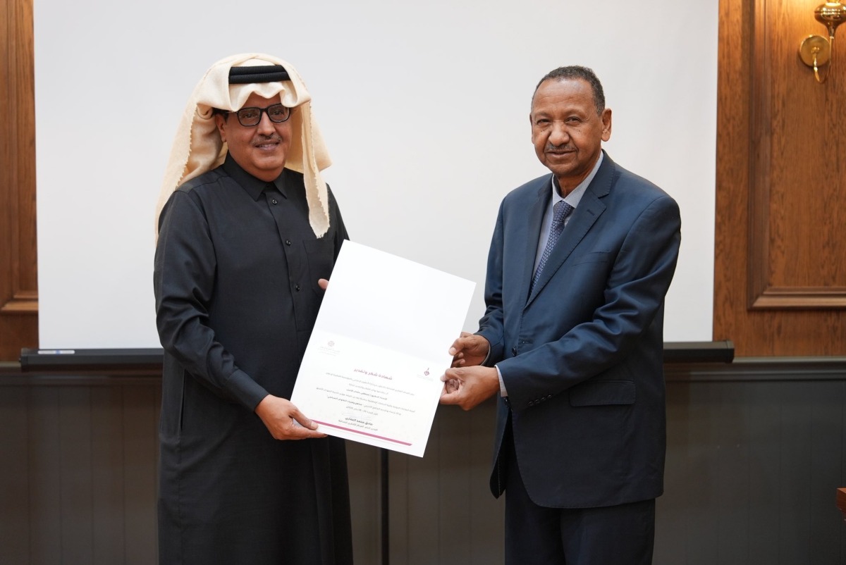 Director General of the Qatar Press Center Sadiq Mohammed Al-Amari (left) honouring former Sudanese Minister of Foreign Affairs, and Professor of Islamic Studies at Hamad Bin Khalifa University Dr. Mustafa Osman Ismail. 