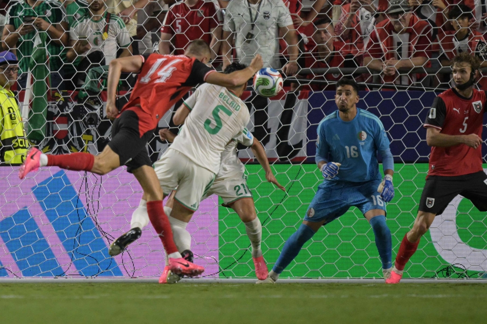 Austria's forward #14 Sasa Kalajdzic heads the ball to score his team's third goal. (Photo by Juan Mabromata / AFP)