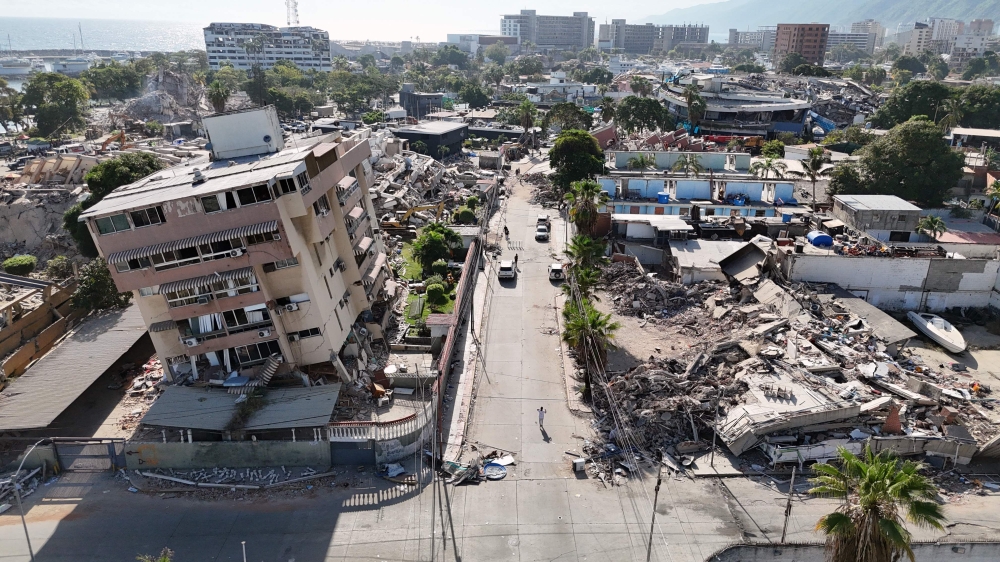 This aerial view shows a heavily damaged coastal area with collapsed buildings and debris following the June 24 twin earthquakes in Caraballeda, La Guaira State, Venezuela, on June 29, 2026. (Photo by Yorman Maldonado/ AFP)