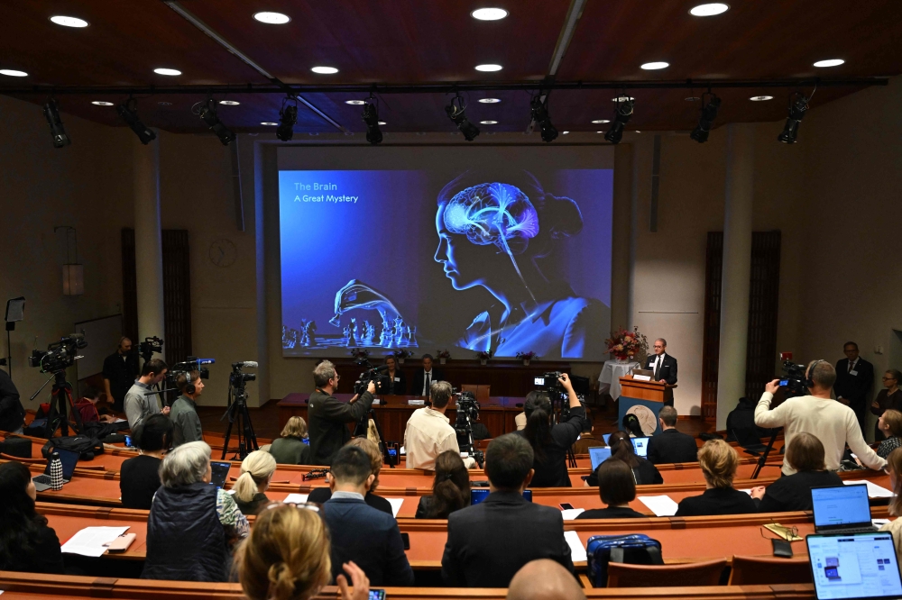Karolinska Institute neuroscience professor Abdel El Manira speaks in front of a screen displaying an illustration of the human brain during the announcement of the winners of the 2026 Nobel Prize in Physiology or Medicine at the Karolinska Institute in Stockholm, Sweden, on October 5, 2026. (Photo by Jonathan Nackstrand / AFP)
